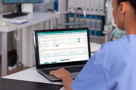 Ein Monitor, auf dem die Verordnungssoftware MediSuite in der Detailansicht die eRezept-Verordnungsübersicht zeigt