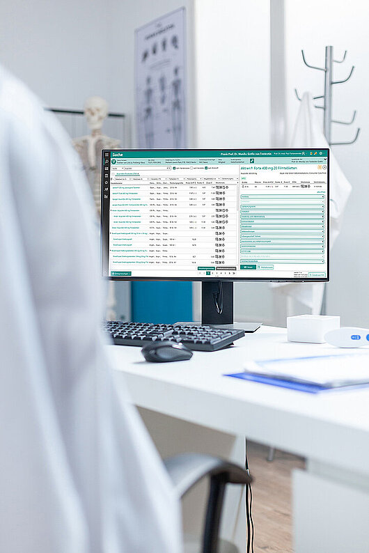 Ein Monitor, auf dem die Verordnungssoftware MediSuite in der Detailansicht die MediSuite-Suche nach Ibuprofen zeigt